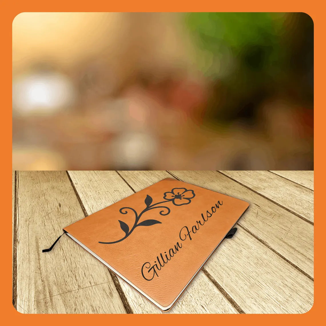 A personalized leather notebook with a floral design on a wooden table.