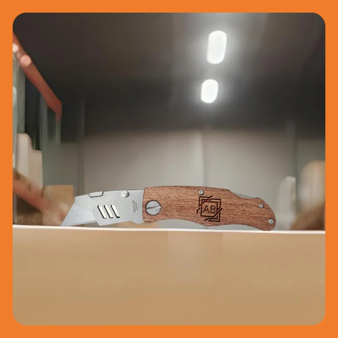 A folding knife with a wooden handle, displayed on a counter in a warehouse setting.