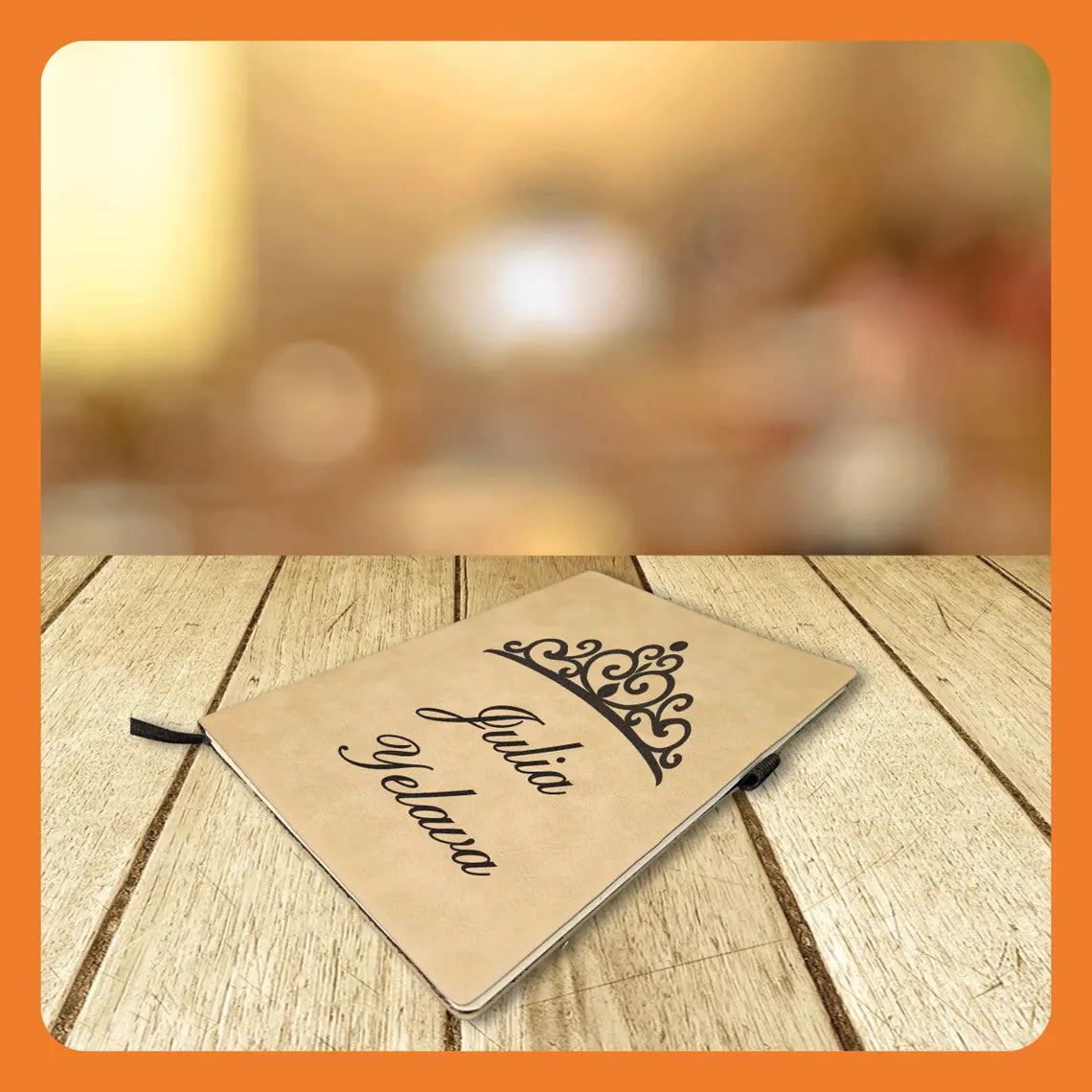A personalized notebook with a crown design and the name 'Julia Velava' on a wooden surface.