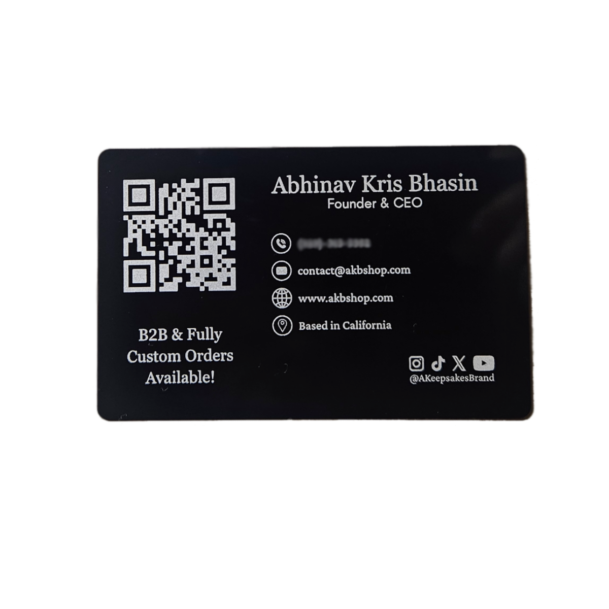 Black business card with white text and QR code on a white background